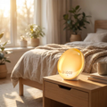 Sunrise Wake-Up Alarm Clock Lamp glowing on a nightstand at dawn