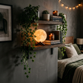 Artificial hanging ivy vine draped over a shelf next to a glowing moon lamp